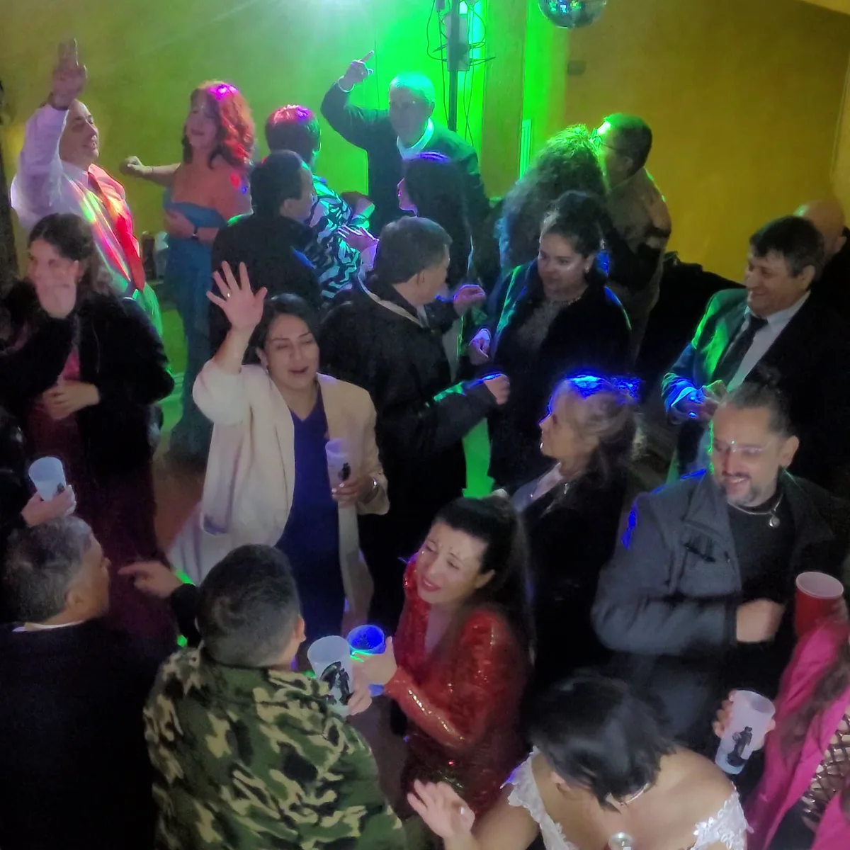 Invitados bailando juntos bajo luces de fiesta durante una celebración