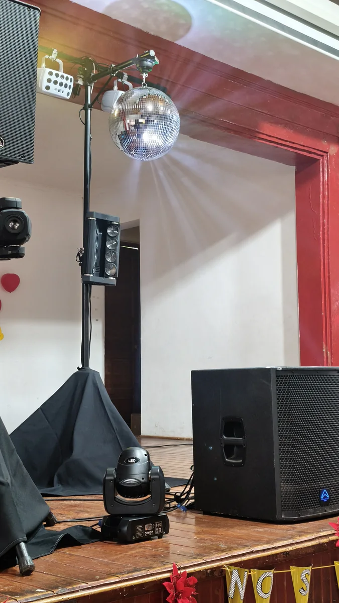 Montaje de parlantes, luces y bola de espejos para una celebración