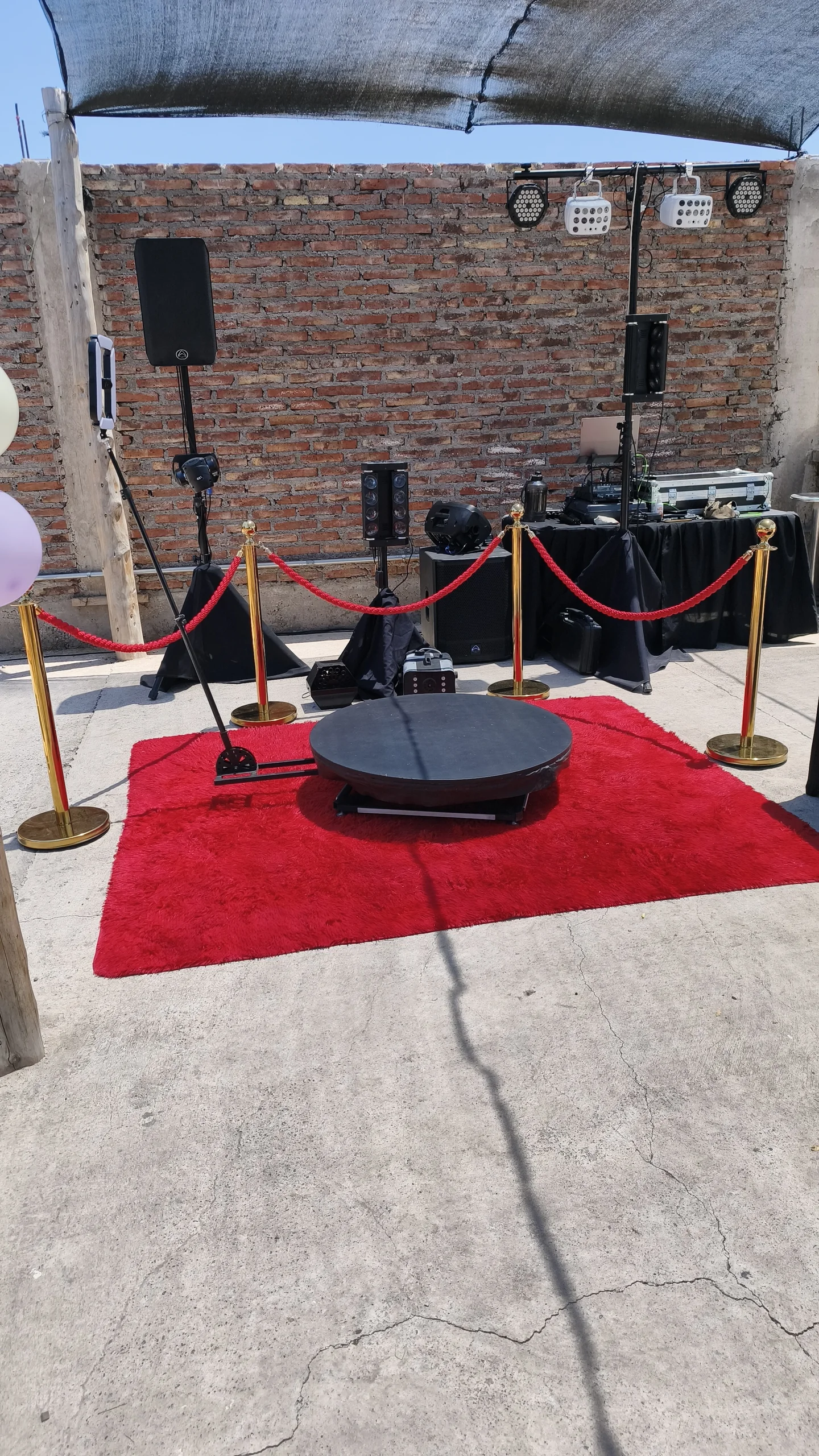 Plataforma 360 con alfombra roja, separadores y equipos de sonido instalados al aire libre